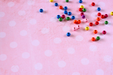colorful beads on pink vintage background with polka dots