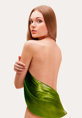 Naklejka premium beautiful woman covering with big leaf