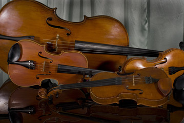 Fototapeta premium Two Violins, Viola and Cello on Piano on Curtain Background