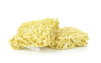 Two blocks of dried egg noodles on a white background