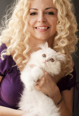 Beautiful young woman holding white Persian kitten