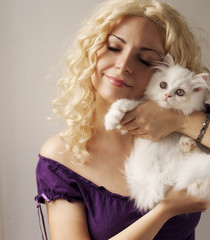 Beautiful young woman holding white Persian kitten