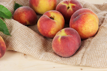Peaches on sackcloth on wooden table