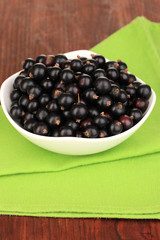 Fresh black currant on wooden background