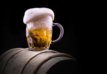 Frosty glass of light beer on black background