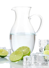 Glass pitcher of water with ice and lime isolated on white