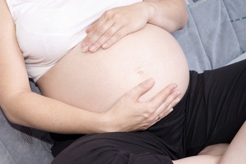 schwangere Frau hält ihren nackten Bauch