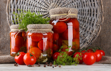 Tasty canned and fresh tomatoes on wooden table