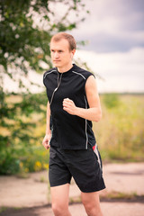 Sportive young man jogging outdoor