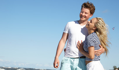 Portrait of a couple posing with the beach as background