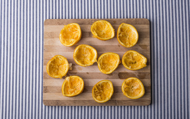 squeezed oranges on a wooden plate