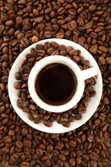Cup of coffee on coffee beans background