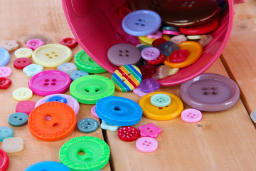 Colorful buttons strewn from bucket close-up