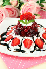 Tasty jelly dessert with fresh berries, on pink roses