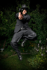 Man in Suit Jumping with Gun