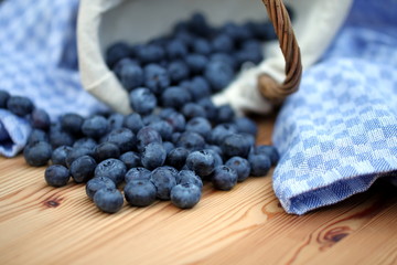 umgefallener Korb mit Heidelbeeren blaues Tuch