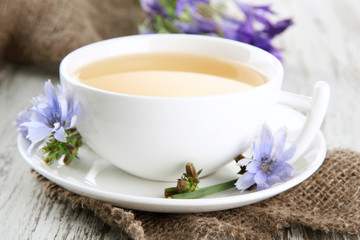 Cup of tea with chicory, on wooden background