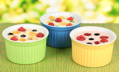 Delicious yogurt with fruit on table on bright background
