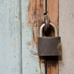 Metal rusty padlock on the old wooden door