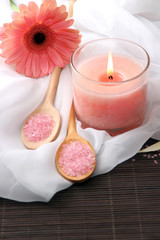 Beautiful pink candle with flower on bamboo mat