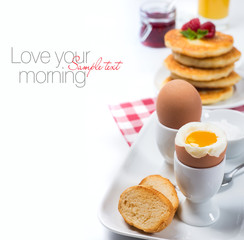 Fresh breakfast with eggs, pancakes, jam and juice