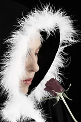 Fototapeta premium Portrait of sad woman in black cape and rose artistic conversion