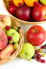 Assortment of juicy fruits in wicker basket and wooden bowl,