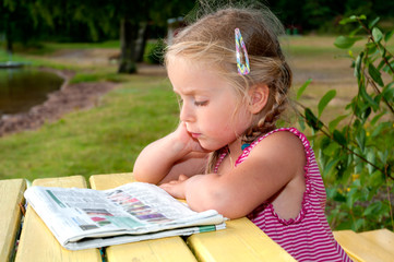 Kleines Mädchen mit Zeitung