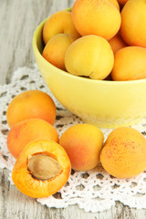 Fresh natural apricot in bowl on green wooden table
