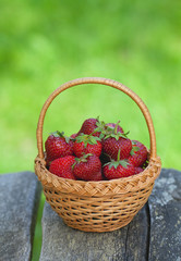 basket with strawberries on wooden surface