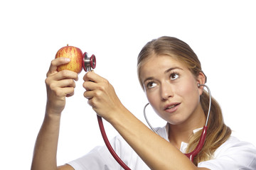 Junge Krankenschwester hört Apfel ab