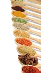 Wall murals Herbs 2 Assortment of spices in wooden spoons, isolated on white