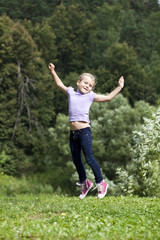 Happy little girl jumping in summer day