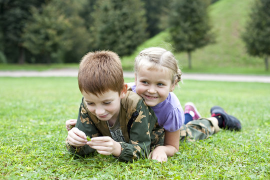 Children lying on the green grass in the park