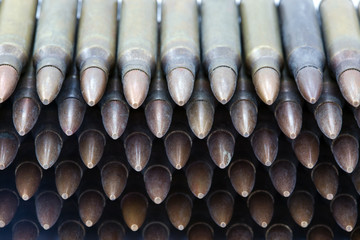 A stack of 5.56mm rifle cartridges. Shot from a high angle.