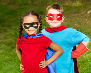 Pretty mixed race girl and boy pretending to be superheroes