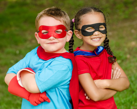 Pretty mixed race girl and boy pretending to be superheroes