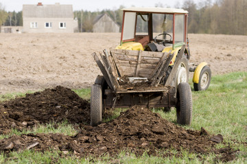 Old Rustic Tractor Delivering Manure.
