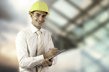 Young architect wearing a protective helmet standing on the buil