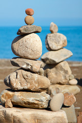 balanced stones, pebbles stacks against blue sea