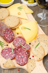 salami, cheese, crackers, olives and glass of wine, top view