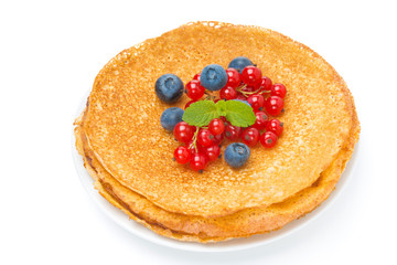 stack of crepes with red currants and blueberries on a plate