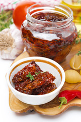 sun dried tomatoes and spices on wooden board, close-up