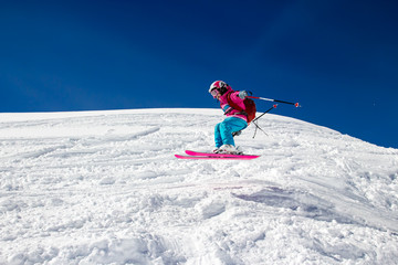 Little girl skier flies over the slope