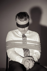 Kidnapped businessman. Black and white image of Tied up man in s
