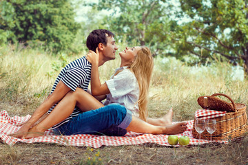 young couple on picnic, sitting face to fa