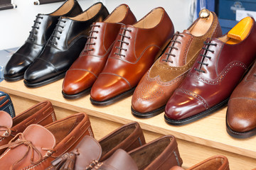Zapatos brillantes de cuero de caballero expuestos en tienda para su venta minorista, producto de...