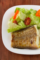 fried fish with salad on the plate