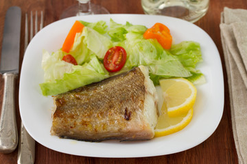 fried fish with salad and lemon