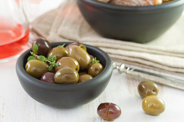 olives in black bowl and pink wine